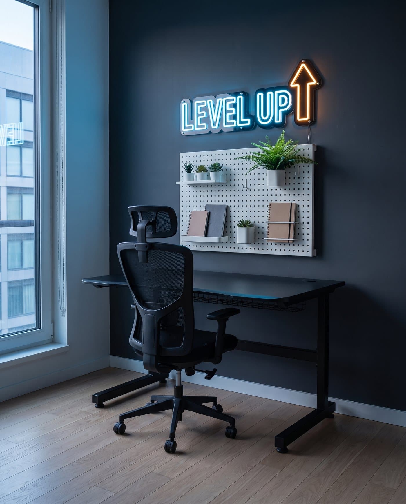 Coin gaming : bureau noir, chaise en maille, pegboard blanc garni de plantes et néon Level Up au mur