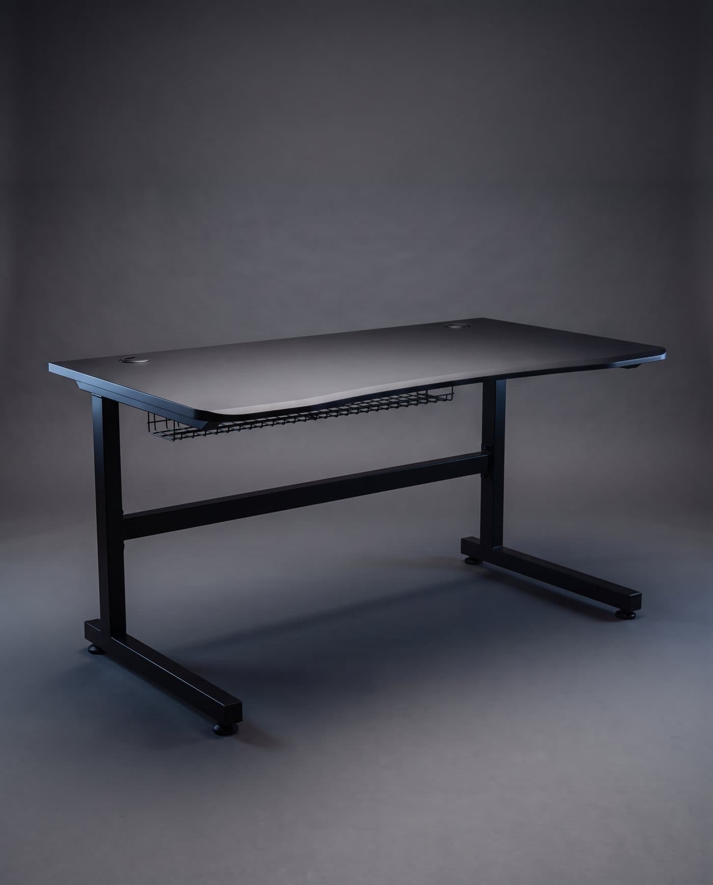 Bureau noir mat de 160 cm sur cadre en acier noir, goulotte à câbles sous le plateau, sur fond anthracite