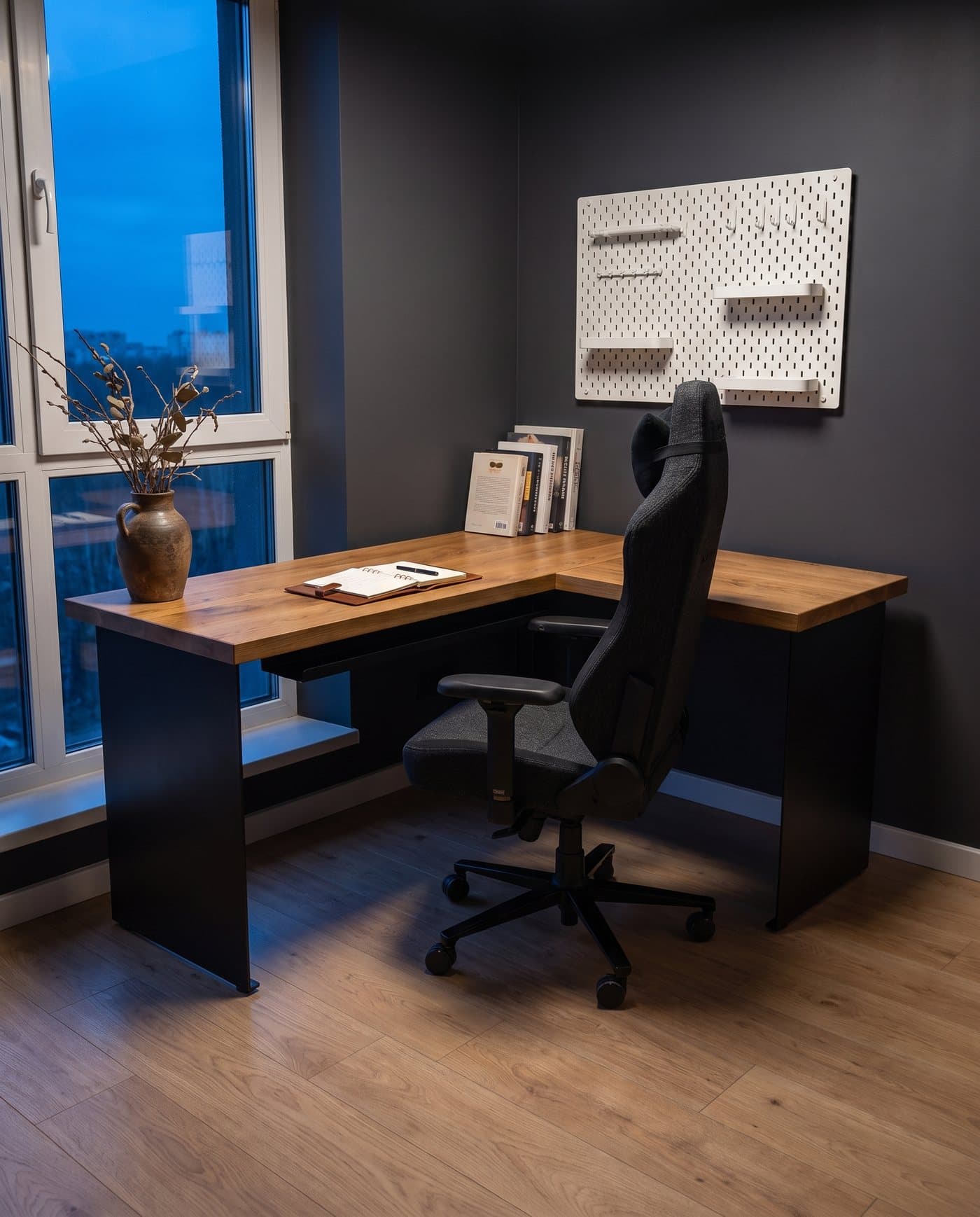 Le bureau Endgame dans l'angle d'une pièce, près d'une grande fenêtre à la tombée du jour
