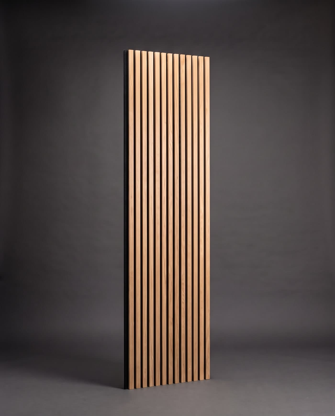 Panneau acoustique vertical à lattes de chêne sur feutre noir, debout sur fond anthracite